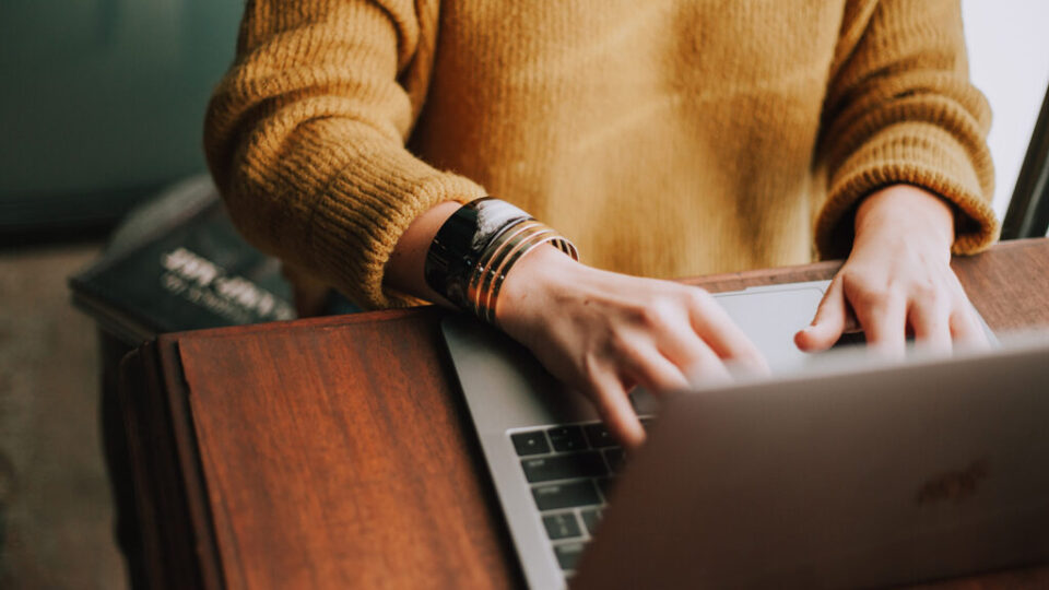 Hands typing on computer.